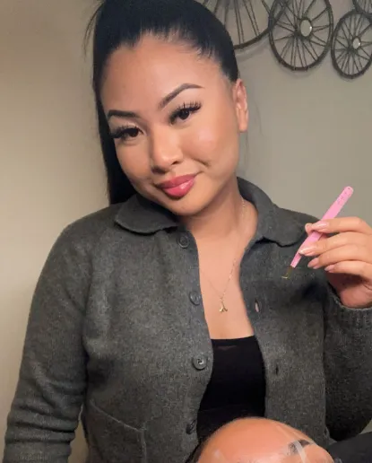 Anjee, the lash and nail stylist behind BY BBYS, holding lash tweezers