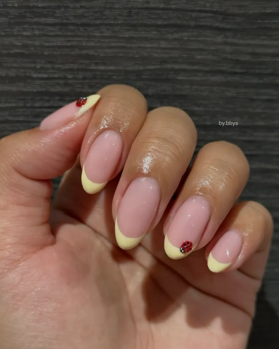 Almond yellow French tips with ladybird accents by BY BBYS, lash and nail studio in Kelham Island, Sheffield